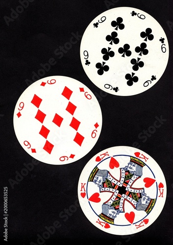 A hand of three vintage round playing cards isolated on a black background.