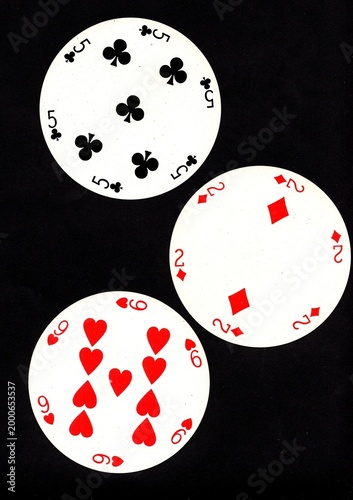 A hand of three vintage round playing cards isolated on a black background.