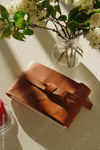 Journal, leather, notebook, diary, flowers, vase, table, sunlight, decor, cozy scenes show a calm writing space with natural materials and soft light in a minimalist home