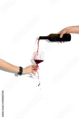 Konstfotografi Red wine splashing from tilted glass while pouring isolated on white background