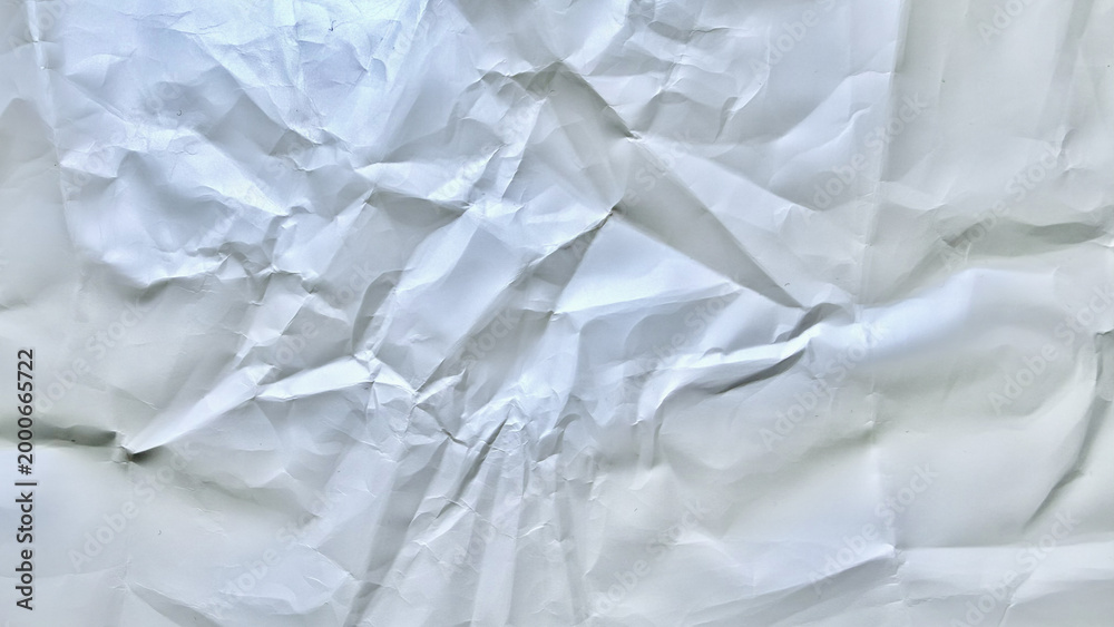 Fototapeta premium intricately crumpled white paper texture with deep folds subtle shadows and irregular creases on plain backdrop