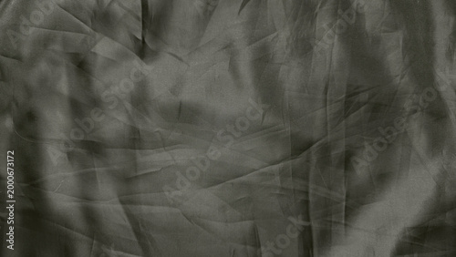 crumpled gray fabric texture closeup with intricate ribbed patterns shadowy folds and enigmatic depth in abstract minimalist composition