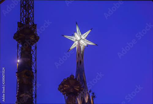 New star on the tower of the Virgin Mary in the Basilica of the Sagrada Familia. the second tallest of Barcelona iconic church. Exterior shot from public floor. Night view.