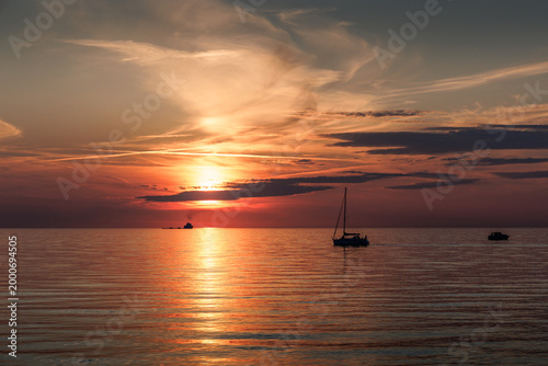 Boot auf der Ostsee bei Warnemünde im warmen Licht eines stimmungsvollen Sonnenuntergangs