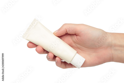 Beige cream tube in woman hands isolated on white background. Skin care concept.