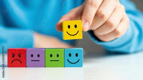 Person choosing happy face emoticon block.