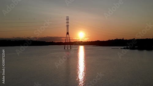 Sunset at Hietaniemi Beach in Helsinki, Finland, with warm golden light reflecting across the Baltic Sea. Calm water and soft sky tones create a peaceful Nordic coastal atmosphere.