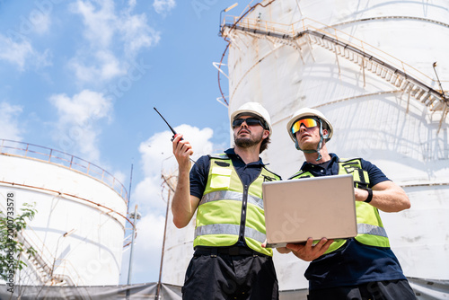Schilderij op canvas Refinery engineers low angle view at industrial plant representing authority and