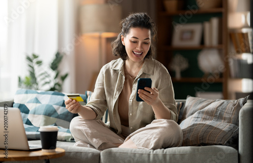 Foto Happy Woman Shopping Online with Credit Card and Smartphone at H
