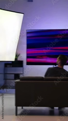 A Man Engrossed in Visual Transformations: From a Blank Slate to a Vibrant Display of Colors on the Screen in a Modern Living Room Setting