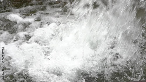 Powerful rushing water stream creating bubbles and foam