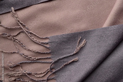 Close up of a textile fabric. Colorful wool scarf with tassels. Brown wool scarf with tassels
