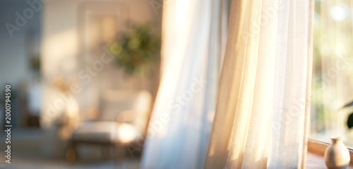 Εκτύπωση καμβά A softly lit interior scene showcasing sheer curtains, creating a warm ambiance with blurred furniture and greenery in the background