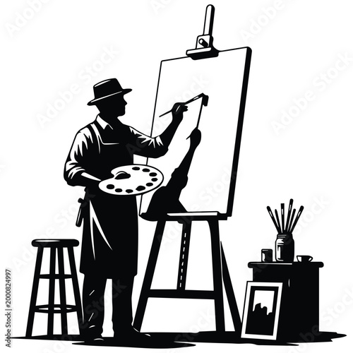 Artist silhouette painting on a canvas at an easel in studio