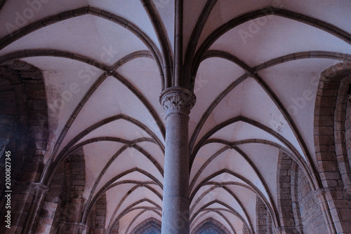 Tableau sur toile Mont Saint-Michel, France: Dramatic low angle view of vaulted ceilings and ribbed arches in the medieval scriptorium of the abbey