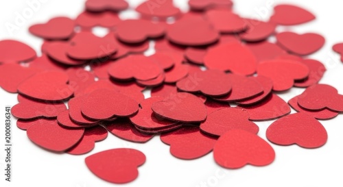 A pile of small red paper heart shapes scattered together for a romantic celebration or wedding party decoration