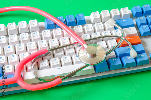 A stethoscope resting on a computer keyboard.