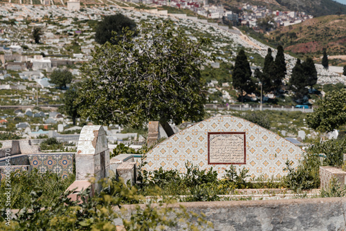Tetouan Jewish Cemetery featuring ancient graves and headstones, traditional Moroccan architecture, and hillside landscape