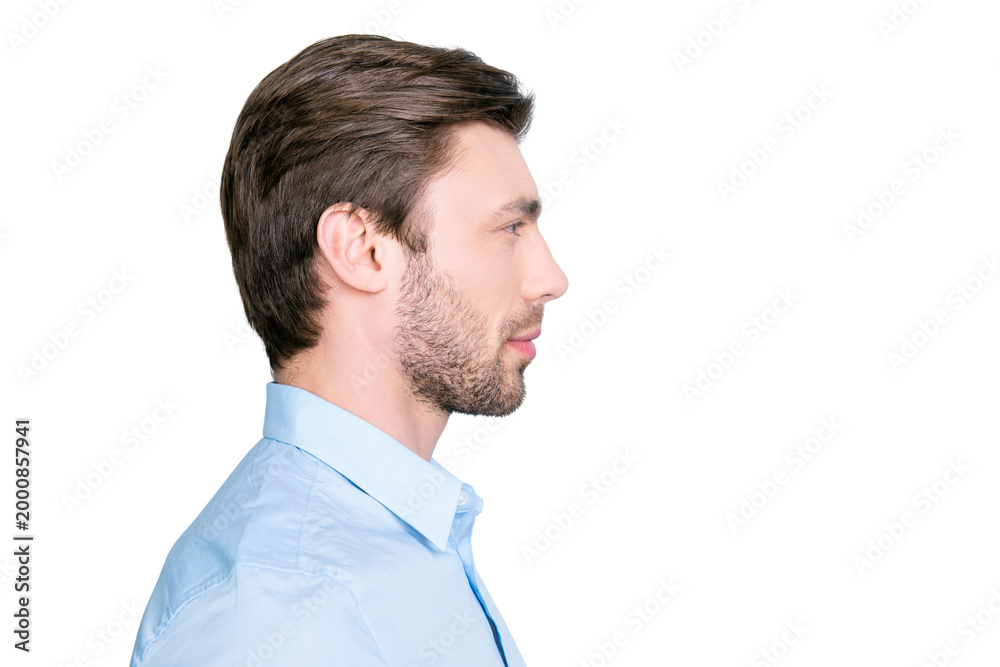 Obraz premium Close up side portrait of young bearded manager standing over grey background with copy space