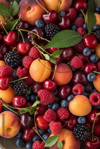 Abundant harvest of summer fruits including juicy apricots, cherries, and mixed berries