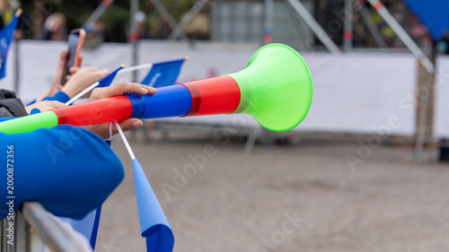Photos Person holding a bright vuvuzela horn at a stadium or festival