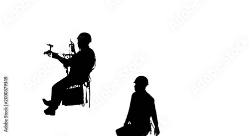 Man playing guitar while another listens silhouette style