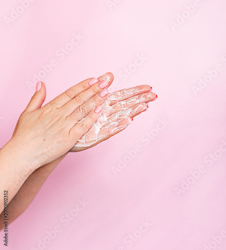 soapy female hands on a pink background