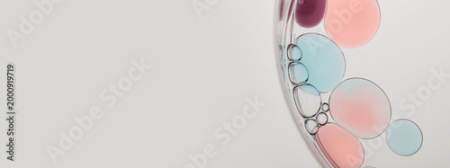 Abstract science background with colorful liquid mixing, forming bubbles and droplets