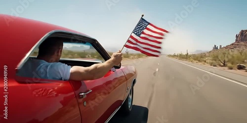 Man Driving Red Classic Muscle Car Waving American Flag in Desert