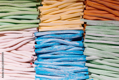 Assorted colorful licorice ropes and jelly string candies in a sweet shop.