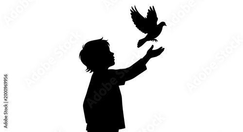Silhouette of a young child releasing a dove into the air.