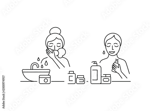 Woman washing face with soap and water and applying cream on face with various skincare products on table