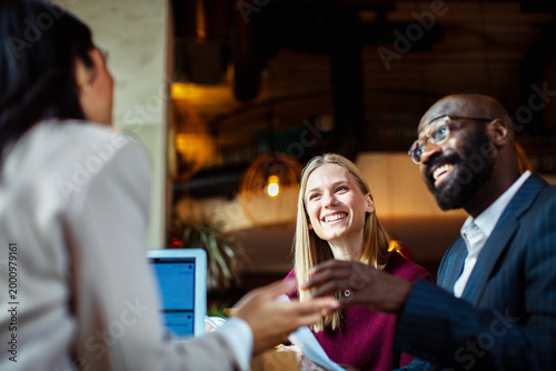 Two clients meeting with advisor in modern cafe