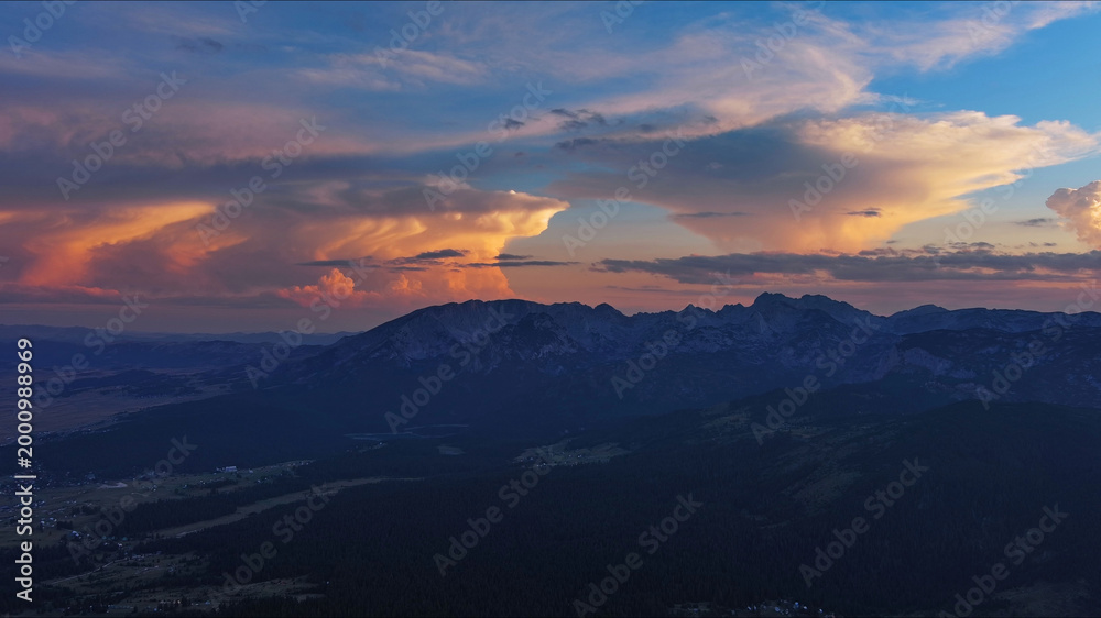 Obraz premium Sun setting over mountain and evening sky