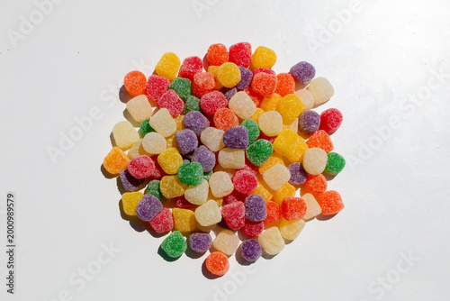 Photography Colorful gumdrops are piled together on a white background each piece coated wit