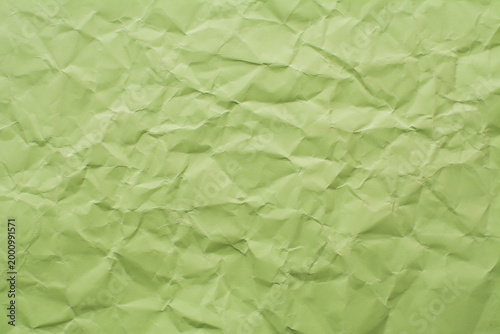 Paper background, wrinkled green paper texture, optimal use of paper in copy space.
