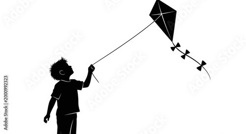 Silhouette of a young boy flying a kite in the sky.