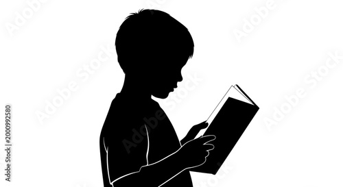 Silhouette of a young boy reading a book.