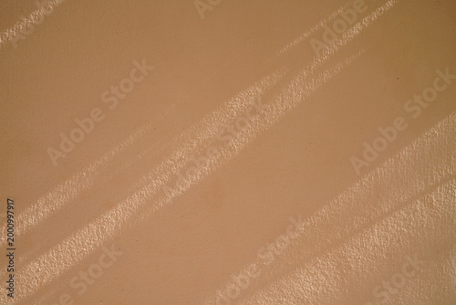 A close-up of a smooth brown surface with diagonal streaks of light and texture.