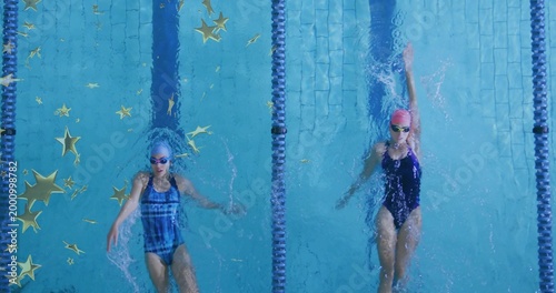 Фотография Swimming two women doing backstroke in lap pool, wearing one-pieces, caps, goggl
