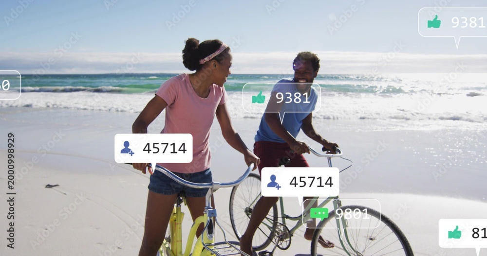 Naklejka premium Riding couple cycling along wet sand beach, wearing casual shirts, showing two bikes, social icons