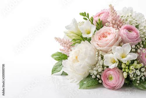 A delicate bouquet of pink and white flowers with drops of water. Space for text.