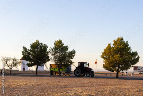 Tractor pulling trailer near windmills in Mota del Cuervo, Spain