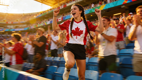 Cheering female fan in Canada maple-leaf jersey raising arms, shouting in stadium, sun flare
