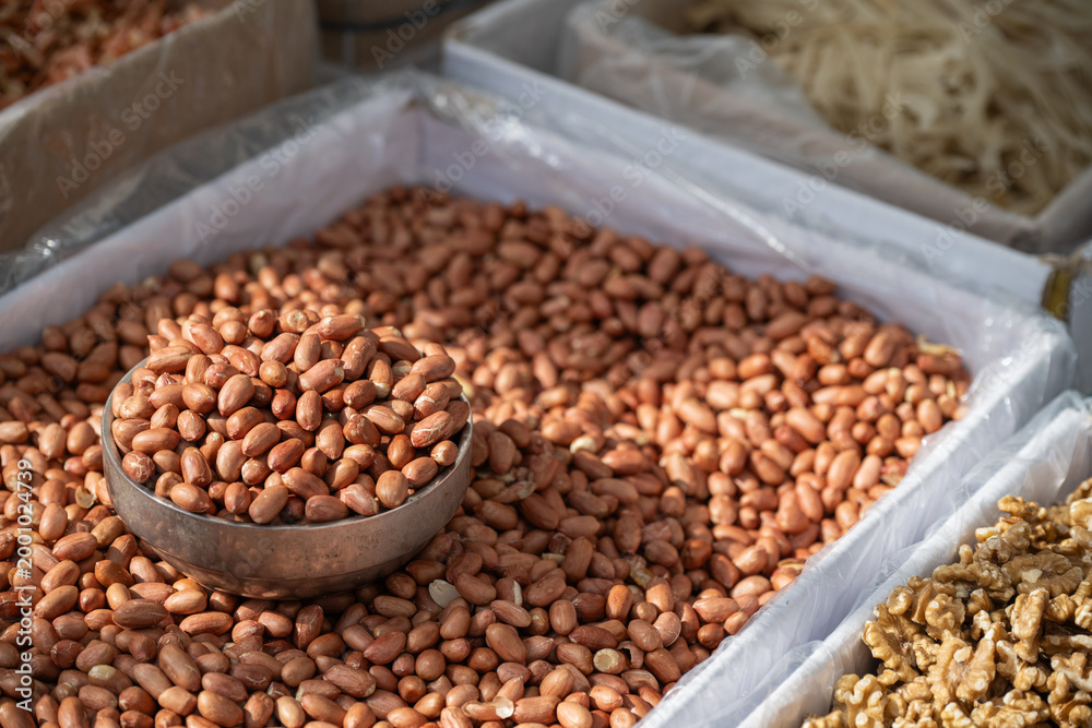 Obraz premium Roasted peanuts in a traditional Korean market stall with a metal scoop in South Korea