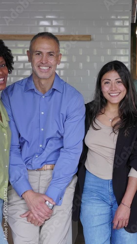 Vertical HD video of group of diverse coworkers smiling together at the office. Multiracial team of professionals collaborating and enjoying teamwork. Business and corporate lifestyle concept.