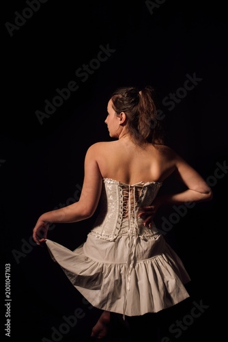 A girl in a white dress, photo shoot on a black background