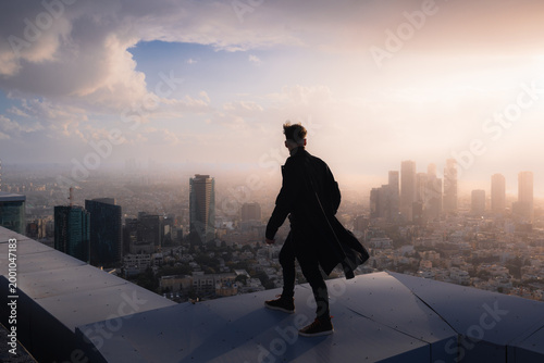 Photos Silhouette of a person walking on a roof during sunset