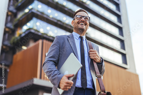 Photos Confident Businessman Carrying Laptop and Leather Bag Outside Modern Office Buil