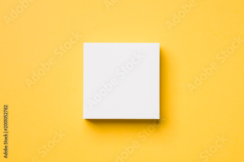 small white cardboard box on a yellow background from top view